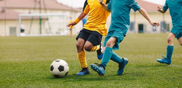 Running Footballers. Children Kicking Soccer School Tournament Match. Multiethnic Children Playing Sports. Young Athletes Compete in Football Game - Photo, Image