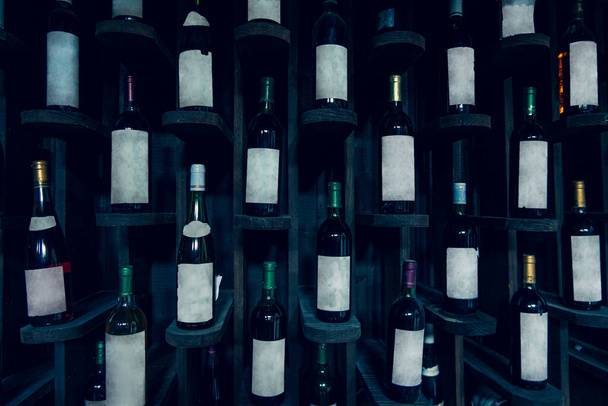 Oude wijnflessen op de wijnplank. Wijnkelder. - Foto, afbeelding