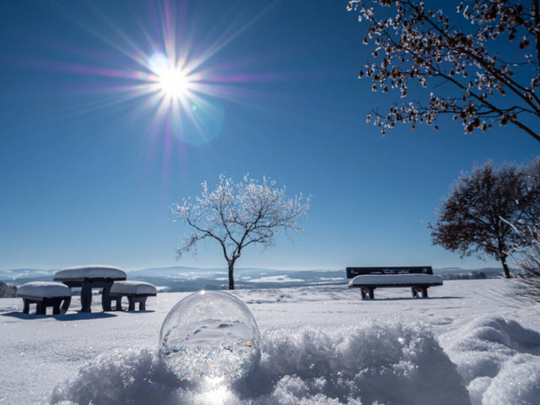 romantische Winterlandschaft in einer Glaskugel im Vordergrund - Foto, Bild