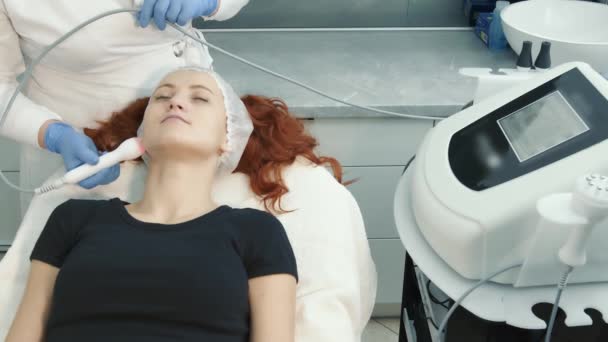kozmetikus elvégzi az eljárást a hardver helyreállítása bőr mikroáram segítségével a modern berendezések egy szépségszalonban - Felvétel, videó