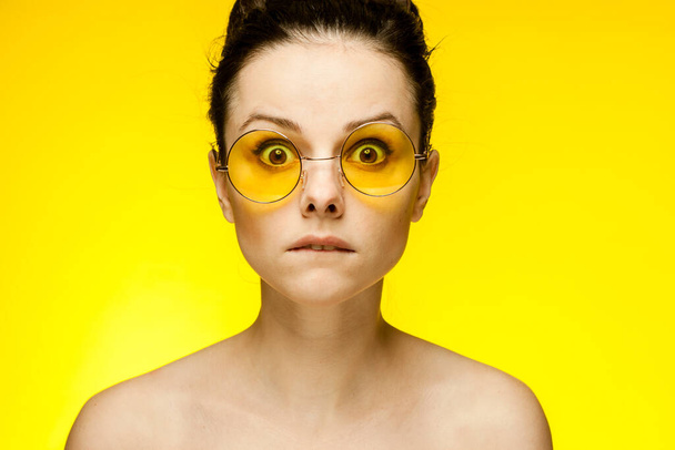 donna con spalle nude capelli raccolti pelle chiara sfondo giallo - Foto, immagini