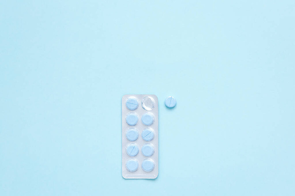 Salud masculina. Blister con píldoras redondas azules sobre fondo azul claro. Tomando medicina. Iniciar tratamiento para la enfermedad. - Foto, Imagen