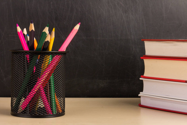 Lápis coloridos em copo de malha de arame, livros sobre mesa de madeira com chalkboard back ground, educação ou de volta ao conceito de escola - Foto, Imagem