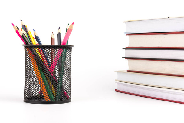 Tel örgü bardaktaki renkli kalemler, beyaz arkaplan, eğitim veya okula dönüş konsepti üzerine kitaplar. - Fotoğraf, Görsel