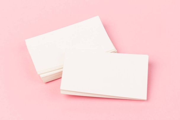 pilas de tarjetas de visita blancas en blanco sobre fondo rosa en primer plano - Foto, imagen