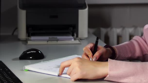 Κλείσιμο των χεριών μιας μαθήτριας που γράφει με στυλό σε ένα βιβλίο αντιγράφων - Πλάνα, βίντεο