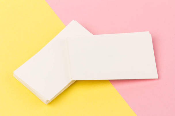 stacks of white blank business cards on pink and yellow background in close-up - Photo, Image