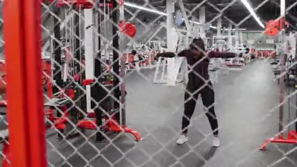 Sporttraining - schwarze Frau trainiert ihre Hände beim Ziehen der Halter, die an dem Gewicht hinter dem Netz befestigt sind - Filmmaterial, Video