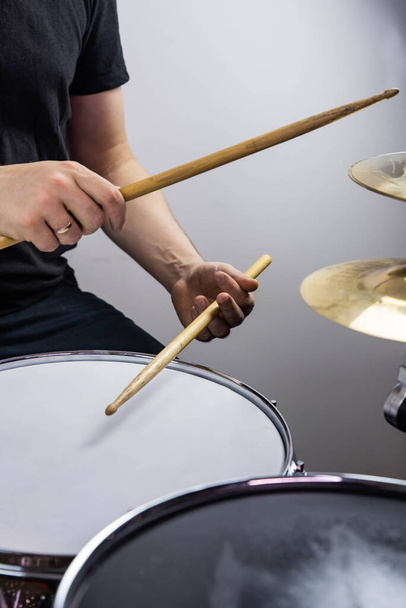 Professional drum set closeup. Man drummer with drumsticks playing drums and cymbals, on the live music rock concert or in recording studio    - Foto, imagen