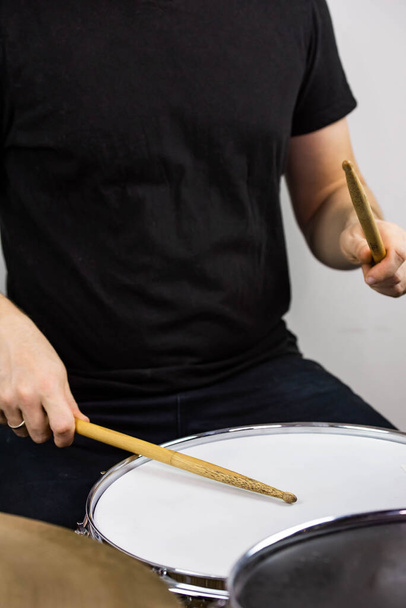Ammatillinen rumpusetti lähikuva. Mies rumpali rumpukapuloilla soittaa rumpuja ja symbaaleja, elävän musiikin rock-konsertissa tai äänitysstudiossa    - Valokuva, kuva