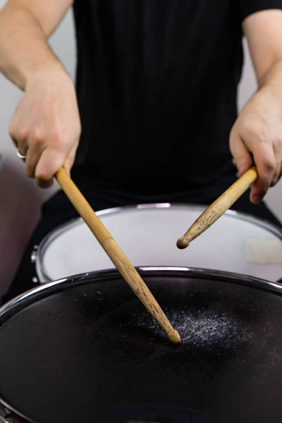 Professionelle Schlagzeug-Nahaufnahme. Mann Schlagzeuger mit Schlagstöcken spielt Trommeln und Becken, auf dem Live-Musik-Rockkonzert oder im Tonstudio    - Foto, Bild