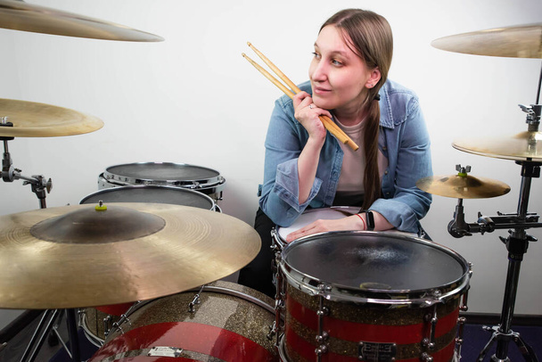 Επαγγελματικό drum set closeup. Όμορφη νεαρή κοπέλα ντράμερ με drumsticks που παίζει τύμπανα και κύμβαλα, στη συναυλία live μουσικής ροκ ή στο στούντιο ηχογράφησης. Γυναίκα ντράμερ. - Φωτογραφία, εικόνα