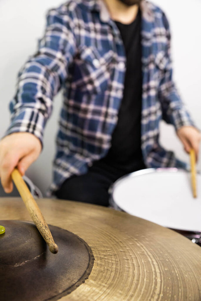 Professional drum set closeup. Man drummer with drumsticks playing drums and cymbals, on the live music rock concert or in recording studio    - 写真・画像