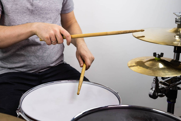 Professional drum set closeup. Man drummer with drumsticks playing drums and cymbals, on the live music rock concert or in recording studio    - Photo, Image