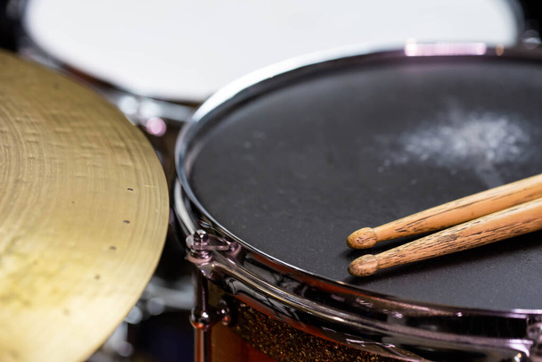 Closeup of drumsticks lying on the professional drum set. Drummer equipment.  - Фото, изображение