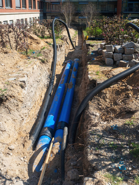 Замена старых водопроводов на современные пластиковые трубы. Укладка подземных коммуникаций в городе Берлин, Германия - Фото, изображение