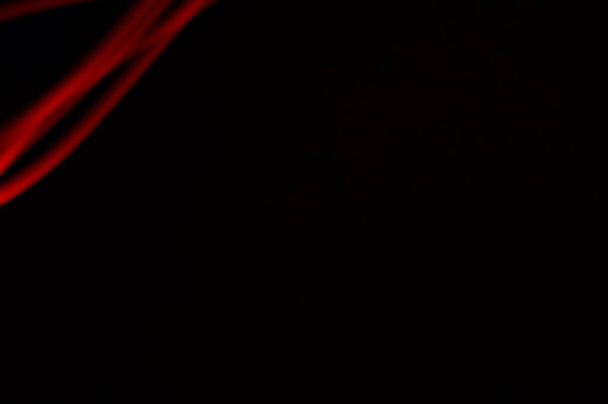 Czerwony rozmazany neon na czarnym tle. Nieregularne linie energii w przestrzeni.Skład światła czerwonego, ślady czerwonej ścieżki. Ilustracja 3d - tło dla napisów lub grafik. - Zdjęcie, obraz