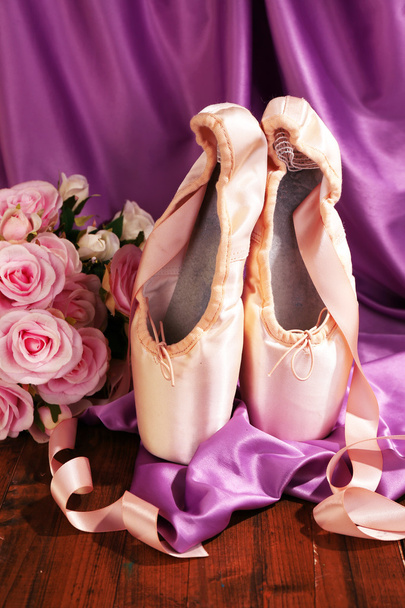 Sapatos de ponteiro de balé no chão de madeira no fundo do tecido
 - Foto, Imagem