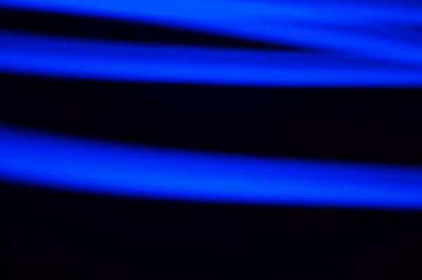 Blauwe dikke lijnen - lichtgevende 3d compositie, op een zwarte achtergrond.Wazig dikke lijnen, in het blauw. 3d illustratie. Uitgebreide en wazige grafische elementen die in de ruimte hangen.  - Foto, afbeelding
