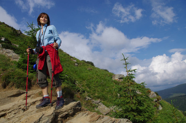 Giovane escursionista che scende dalla collina. Panorama del paesaggio montano. Attività turistiche. - Foto, immagini
