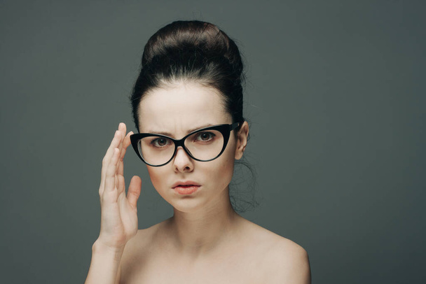 attraktive Frau mit nackten Schultern trägt Brille Glamour Mode grauen Hintergrund - Foto, Bild