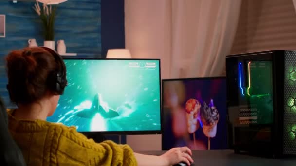 Mujer gamer concentrado sentado en el escritorio, con auriculares - Imágenes, Vídeo