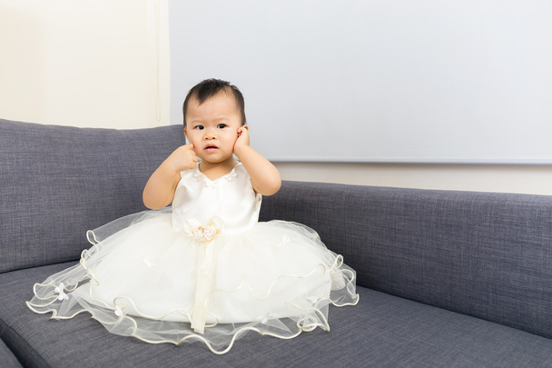 Asiático bebê menina mão tocar sua orelha em casa
 - Foto, Imagem