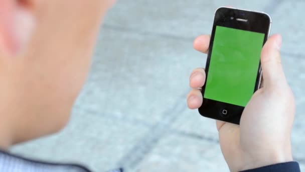 człowiek patrzy na ekran smartphone - zielony - Materiał filmowy, wideo