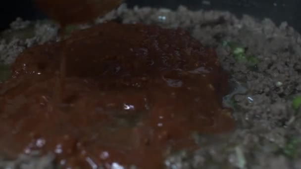 Salsa bolognese che viene aggiunta alla carne macinata bollente. Avvicinamento, Angolo basso, Bloccato - Filmati, video