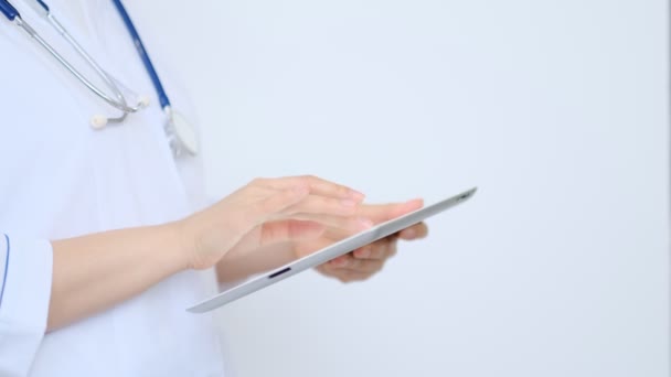 γυναίκα γιατρός σε λευκό εργαστηριακό παλτό χρησιμοποιώντας σύγχρονο ψηφιακό tablet pc. Online ιατρική, υγεία ή ιατρική έννοια του δικτύου. Χέρια του γιατρού που χρησιμοποιούν τον υπολογιστή δισκίο - Πλάνα, βίντεο