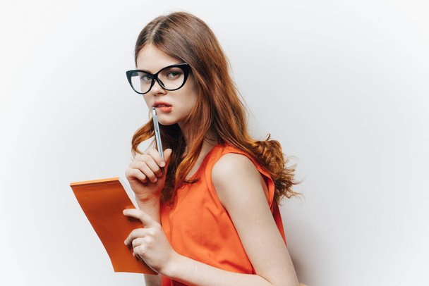 red-haired woman in shirt with notepad charm glasses fashion light background - Photo, image