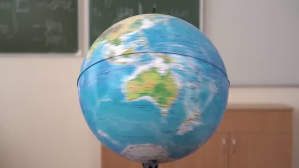 Maapallo pyörii koululautakunnan taustaa vasten. Globe luokassa - Materiaali, video