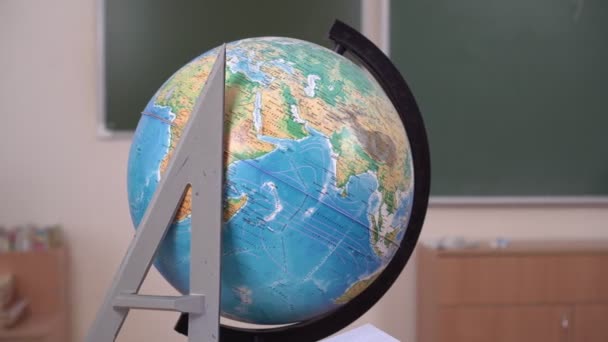 Iskolai földgömb és uralkodó az iskolaszék hátterében. Földrajz óra. Iskolai és oktatási koncepciók - Felvétel, videó