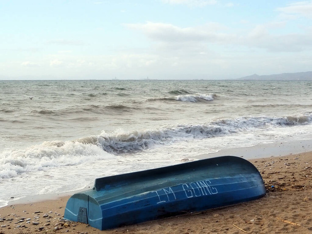 Barco de madera azul solitario con inscripción en una playa cerca de Atenas, Grecia, en un día ventoso de diciembre - Foto, Imagen