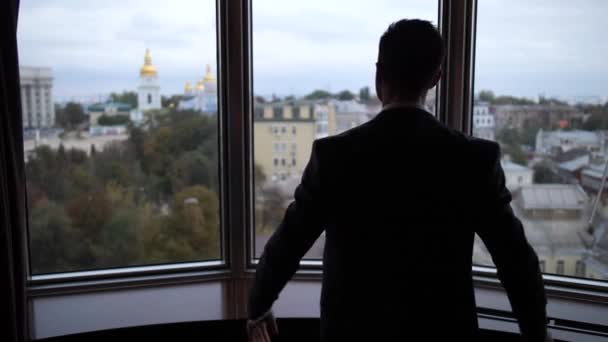 Silhoutte του ανθρώπου τραβώντας κουρτίνες στο δωμάτιο του ξενοδοχείου - Πλάνα, βίντεο