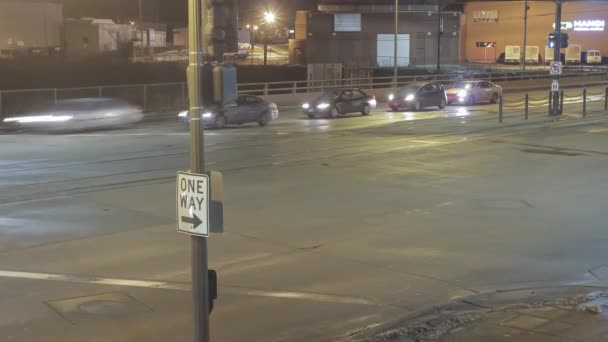 Een middelmatige opname van een "enkele reis" teken in de linker benedenhoek Derde met trein en verkeer op straat 's nachts in lange blootstelling 4K UHD Timelapse - Video