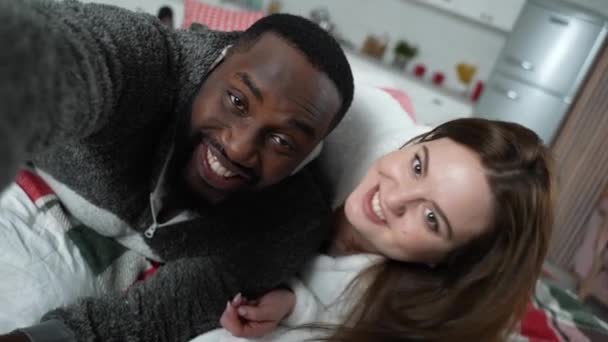 Sonriente pareja multinacional tomando selfie en casa - Metraje, vídeo