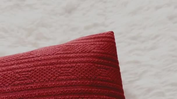 Red throw pillow on white fluffy bedspread cover, home decor - Footage, Video