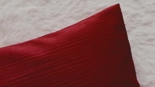 Almohada roja del tiro en la cubierta mullida blanca de la colcha, decoración casera - Metraje, vídeo