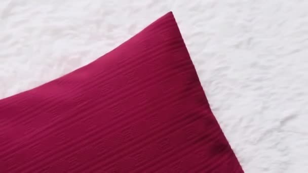 Rotes Wurfkissen auf weißer, flauschiger Bettdecke, Wohnkultur - Filmmaterial, Video