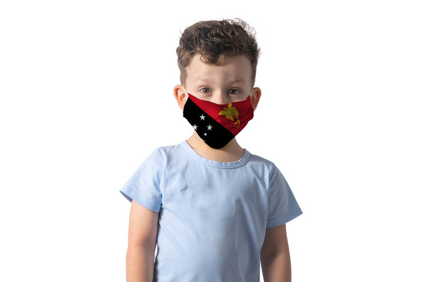 Respirator with flag of Papua New Guinea. White boy puts on medical face mask isolated on white background. - Photo, Image