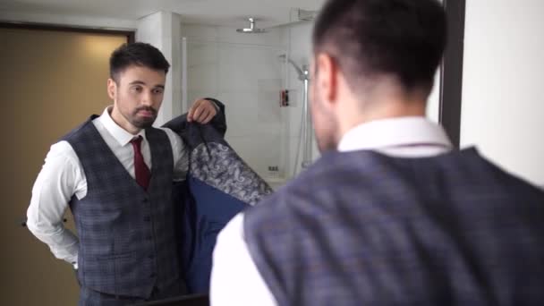 Schöner Mann zieht Anzugjacke im Badezimmer an - Filmmaterial, Video
