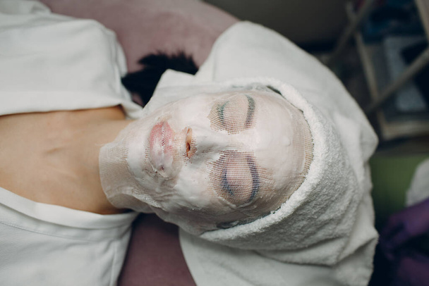 Parafin maskeli sargı bezi, cilt bakımı gören genç kadın terapisi. Güzellik Uzmanı Balmumu Uygulaması - Fotoğraf, Görsel