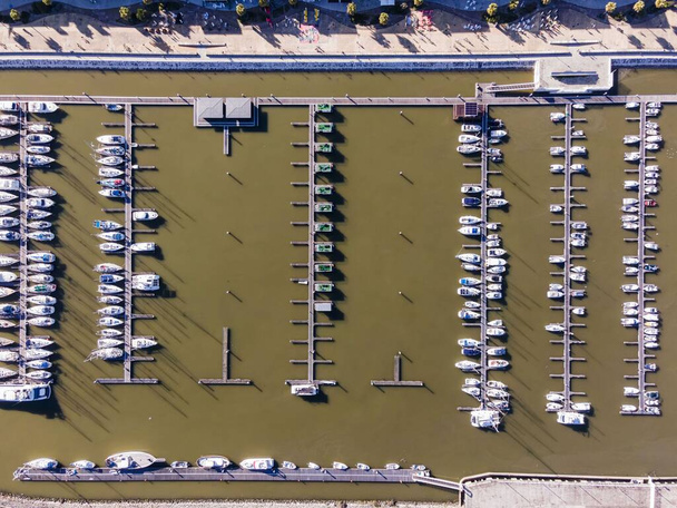 Вид с воздуха на небольшой пирс с катерами и парусными лодками в порту Marina в центре Лиссабона, Ориенте, Лиссабон, Португалия. - Фото, изображение