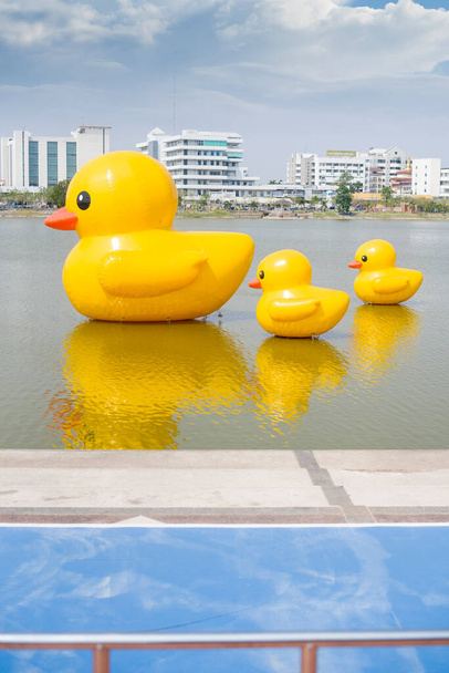 Udon Thani, Tailandia - 17 de febrero de 2021: Tres patos de goma amarillos gigantes flotantes en el lago de la provincia de Udon thani, Tailandia. Tamaño del retrato. - Foto, imagen