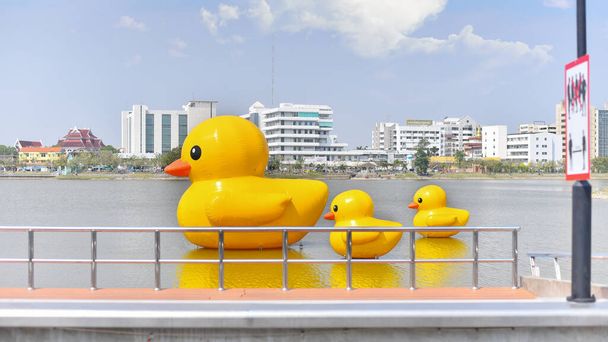 Udon Thani, Tailandia - 17 de febrero de 2021: Tres patos de goma amarillos gigantes flotantes en el lago de la provincia de Udon thani, Tailandia. - Foto, imagen