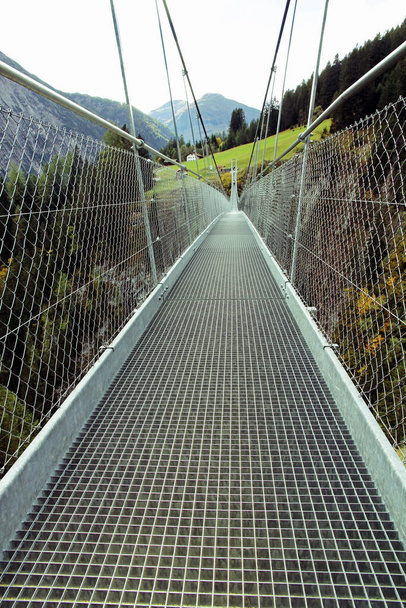 El largo camino sobre el puente. El largo puente colgante en las montañas - Foto, Imagen