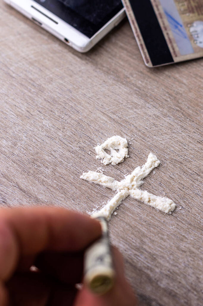признак смертельной опасности, сделанный из полосок кокаина на деревянном столе, короткий фокус, тонизирующий - Фото, изображение