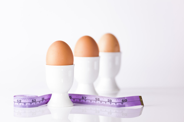 Kolme keitettyä munaa mittanauhalla
 - Valokuva, kuva