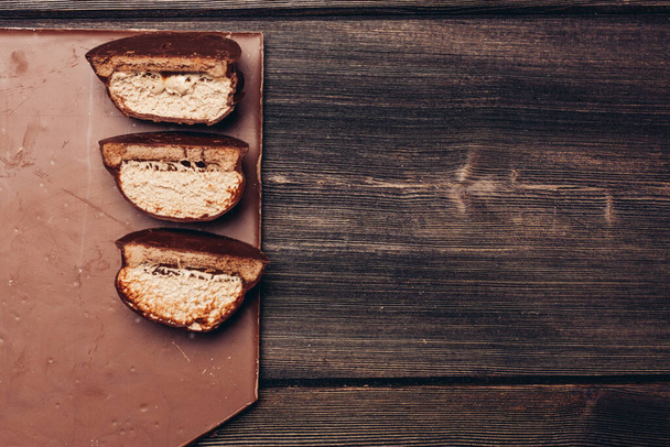 felezett brownie és csokoládé a fa asztalon - Fotó, kép